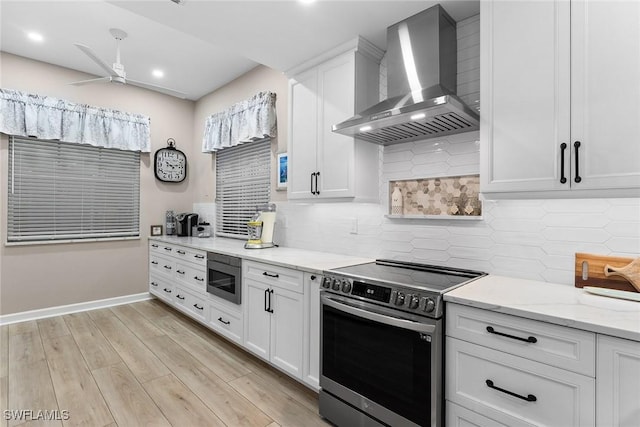 kitchen with white cabinets, wall chimney range hood, electric stove, light stone countertops, and built in microwave