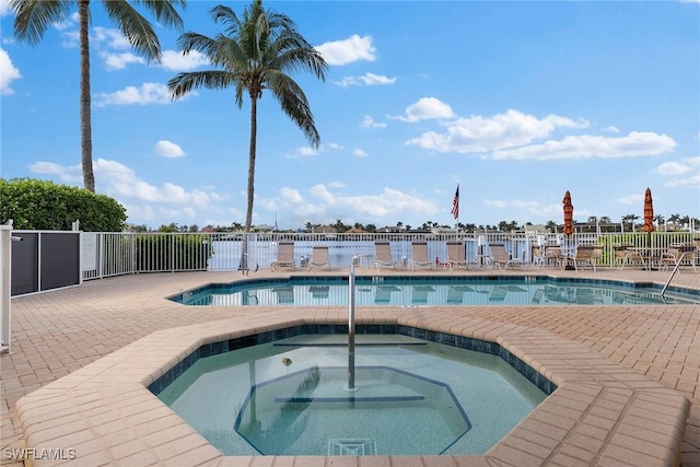 view of swimming pool featuring a hot tub