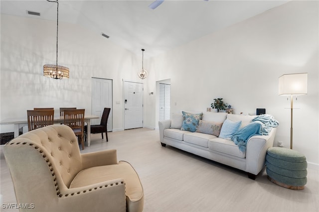 living room with high vaulted ceiling and a chandelier