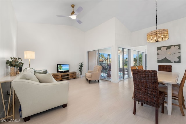 living room with wood-type flooring, ceiling fan with notable chandelier, and vaulted ceiling