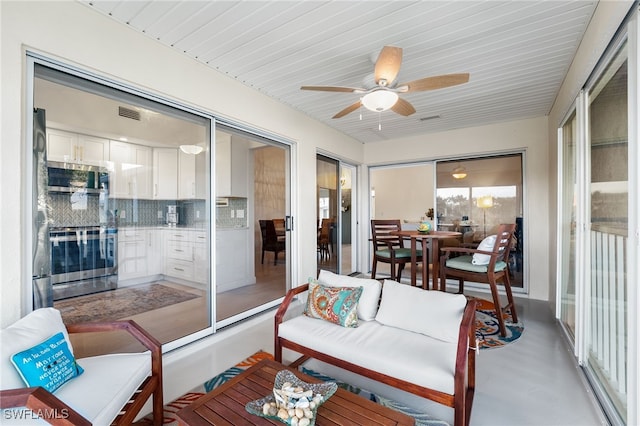 sunroom with ceiling fan and wooden ceiling