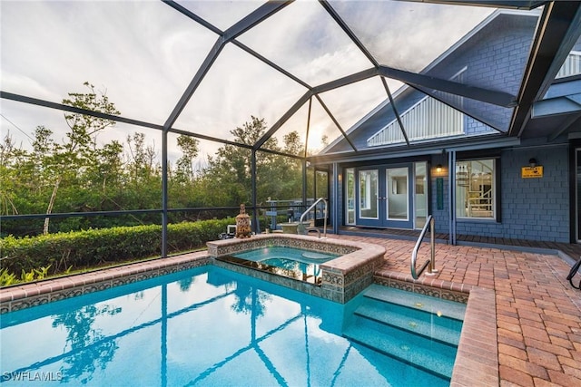 view of pool with glass enclosure, an in ground hot tub, a patio, and french doors