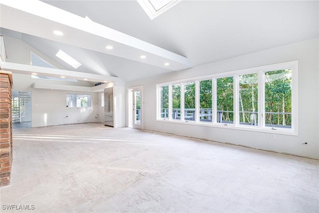 unfurnished living room with plenty of natural light and lofted ceiling