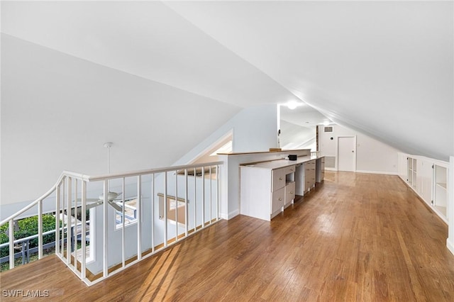 additional living space featuring hardwood / wood-style floors, vaulted ceiling, and ceiling fan