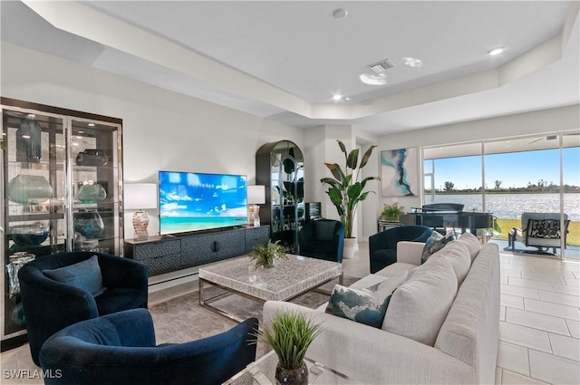 tiled living room with a tray ceiling