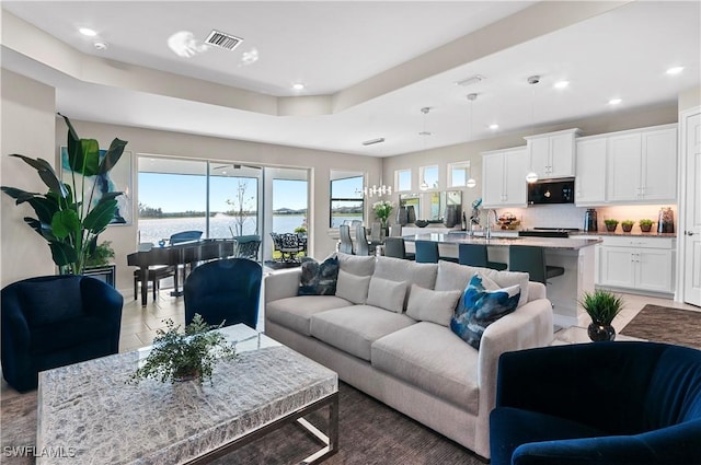 living room featuring a water view and sink