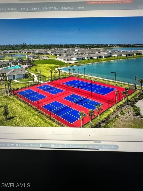 exterior space with tennis court and a water view