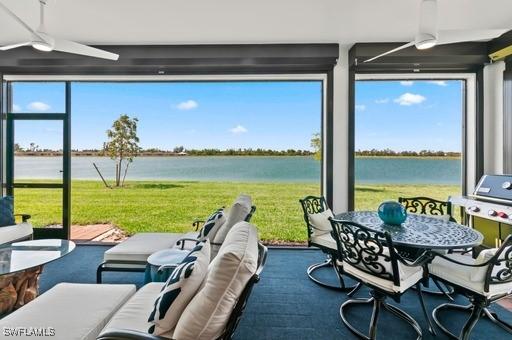 sunroom featuring a water view