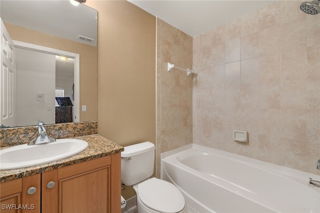 full bathroom with tiled shower / bath, vanity, and toilet