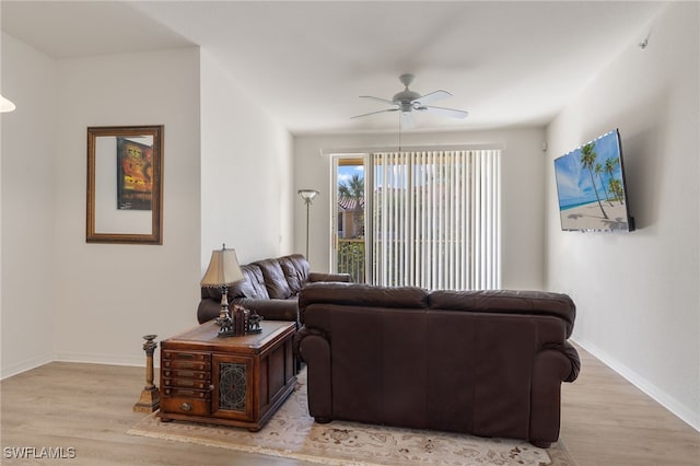 living room with light hardwood / wood-style flooring and ceiling fan