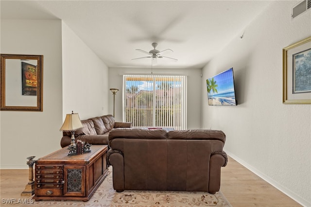 living room with ceiling fan and light hardwood / wood-style flooring