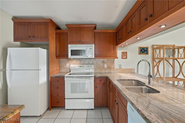 kitchen featuring light tile patterned floors, white appliances, a textured ceiling, and sink