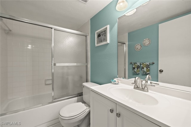 full bathroom featuring vanity, toilet, a textured ceiling, and combined bath / shower with glass door