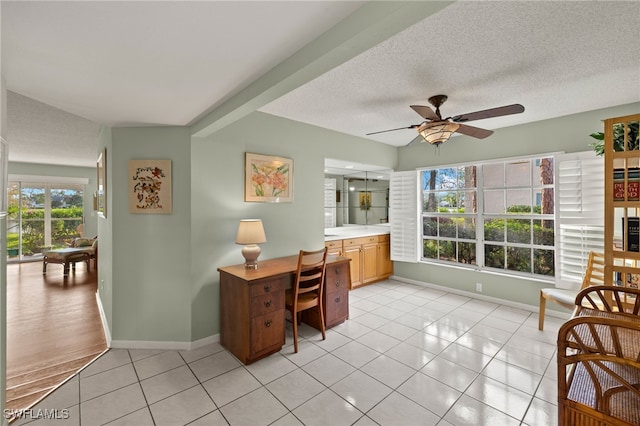 office area featuring ceiling fan, light tile patterned floors, and a textured ceiling