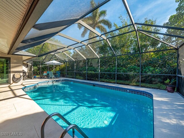 view of swimming pool featuring a patio and glass enclosure