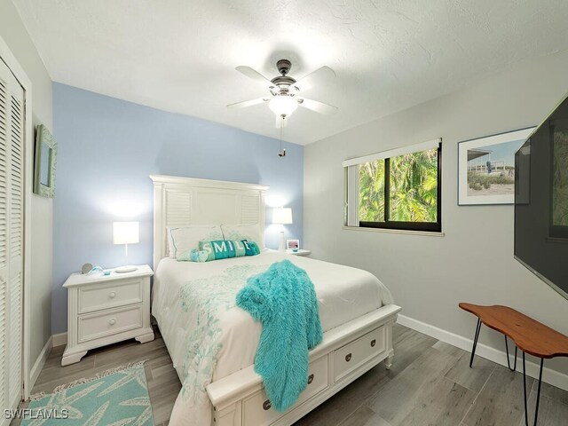 bedroom with ceiling fan, a closet, and hardwood / wood-style floors