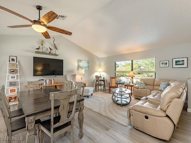 living room featuring ceiling fan, light hardwood / wood-style floors, and vaulted ceiling