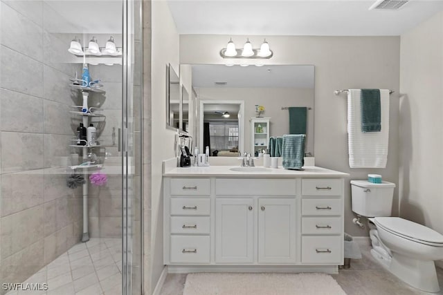 bathroom with tile patterned flooring, vanity, toilet, and an enclosed shower