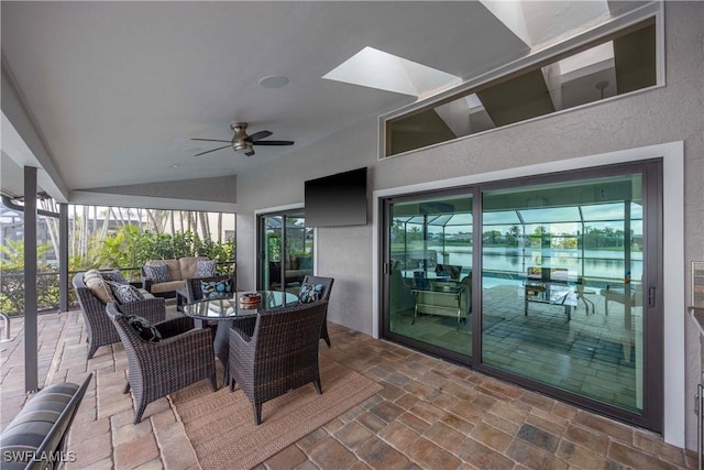 sunroom / solarium featuring ceiling fan and lofted ceiling with skylight