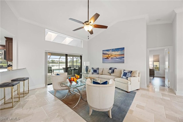 living room with ceiling fan, ornamental molding, and high vaulted ceiling