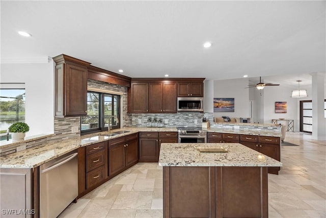 kitchen featuring light stone countertops, sink, stainless steel appliances, backsplash, and kitchen peninsula