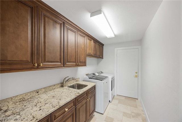 laundry room featuring cabinets, washing machine and dryer, and sink