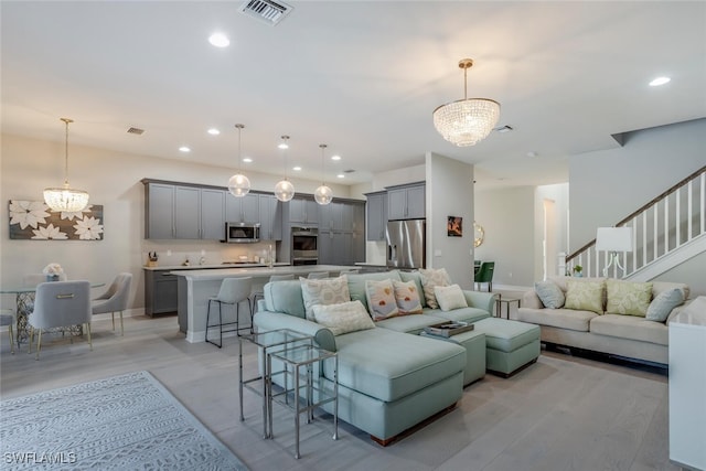 living room featuring a chandelier and light hardwood / wood-style floors