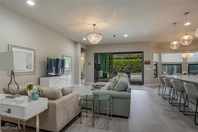 living room featuring light hardwood / wood-style flooring and an inviting chandelier