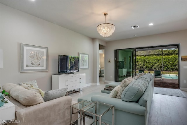 living room with a chandelier and light hardwood / wood-style floors