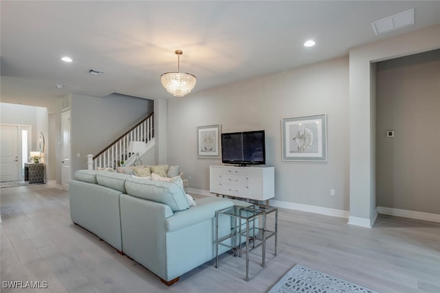 living room with light hardwood / wood-style floors and a chandelier