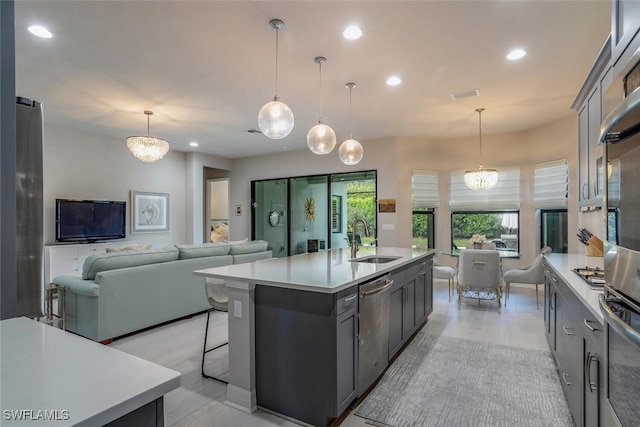 kitchen with decorative light fixtures, an inviting chandelier, and an island with sink