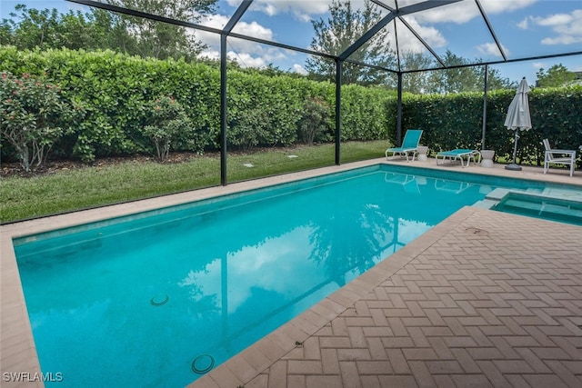 view of pool with glass enclosure and a patio