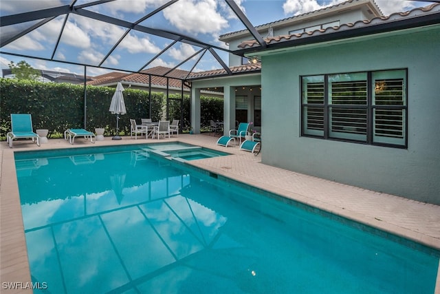 view of swimming pool with an in ground hot tub, a lanai, and a patio area