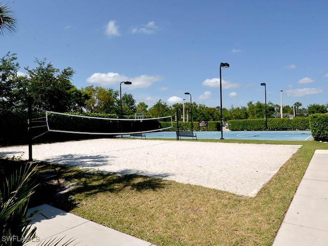 view of property's community with volleyball court and a yard