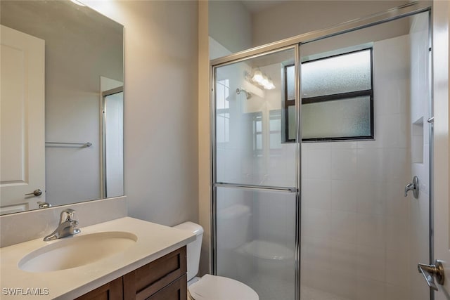 bathroom with vanity, toilet, and a shower with shower door