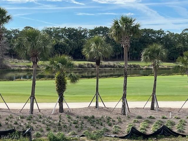 view of community featuring a water view, a yard, and golf course view