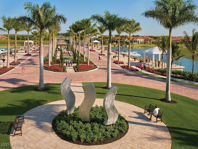 surrounding community with a water view and a yard