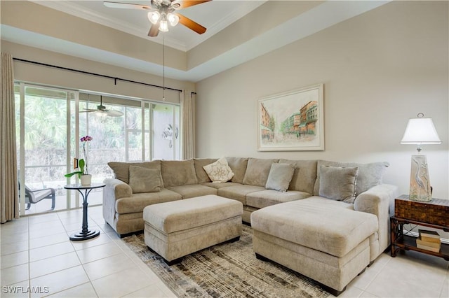 tiled living room featuring a tray ceiling, ceiling fan, and crown molding