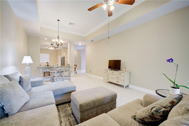 living room with a tray ceiling, ceiling fan with notable chandelier, and ornamental molding