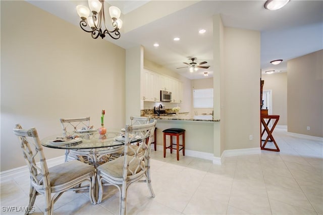 dining area featuring light tile patterned floors and ceiling fan with notable chandelier