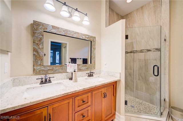 bathroom featuring a shower with door and vanity