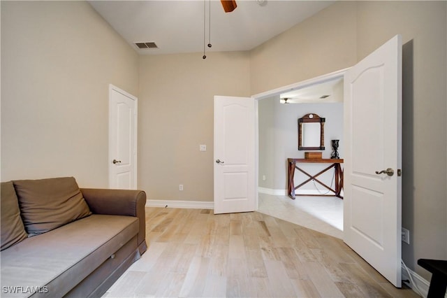 living area with light wood-type flooring and ceiling fan