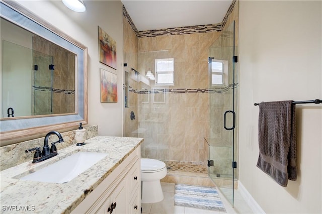 bathroom featuring tile patterned floors, vanity, toilet, and a shower with door