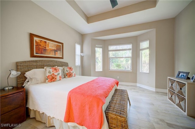 bedroom with ceiling fan and a tray ceiling