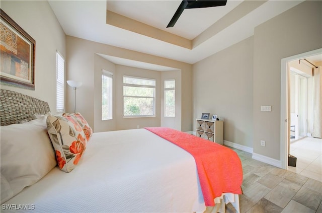 bedroom with a tray ceiling and ceiling fan