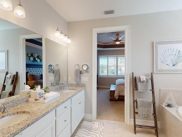 bathroom featuring tile patterned floors, ceiling fan, a relaxing tiled tub, and vanity