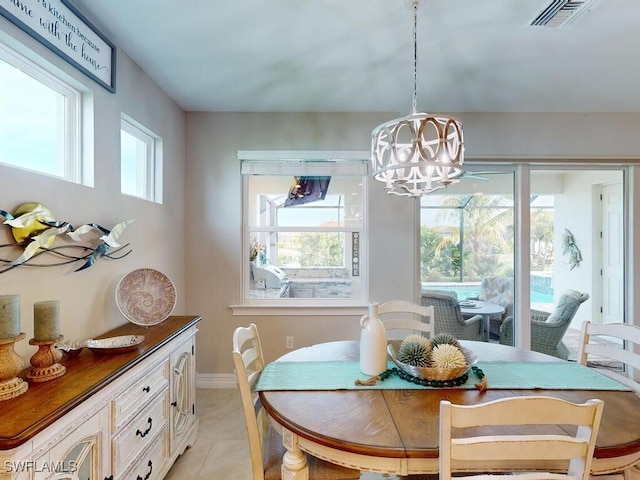 tiled dining space with a chandelier