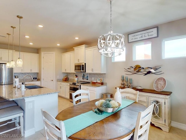 dining area with a wealth of natural light, sink, and light tile patterned floors