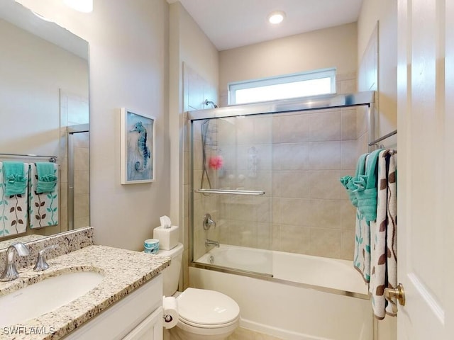 full bathroom featuring vanity, toilet, and bath / shower combo with glass door