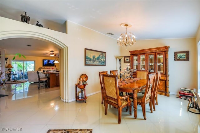 dining area with ceiling fan with notable chandelier, light tile patterned floors, and lofted ceiling